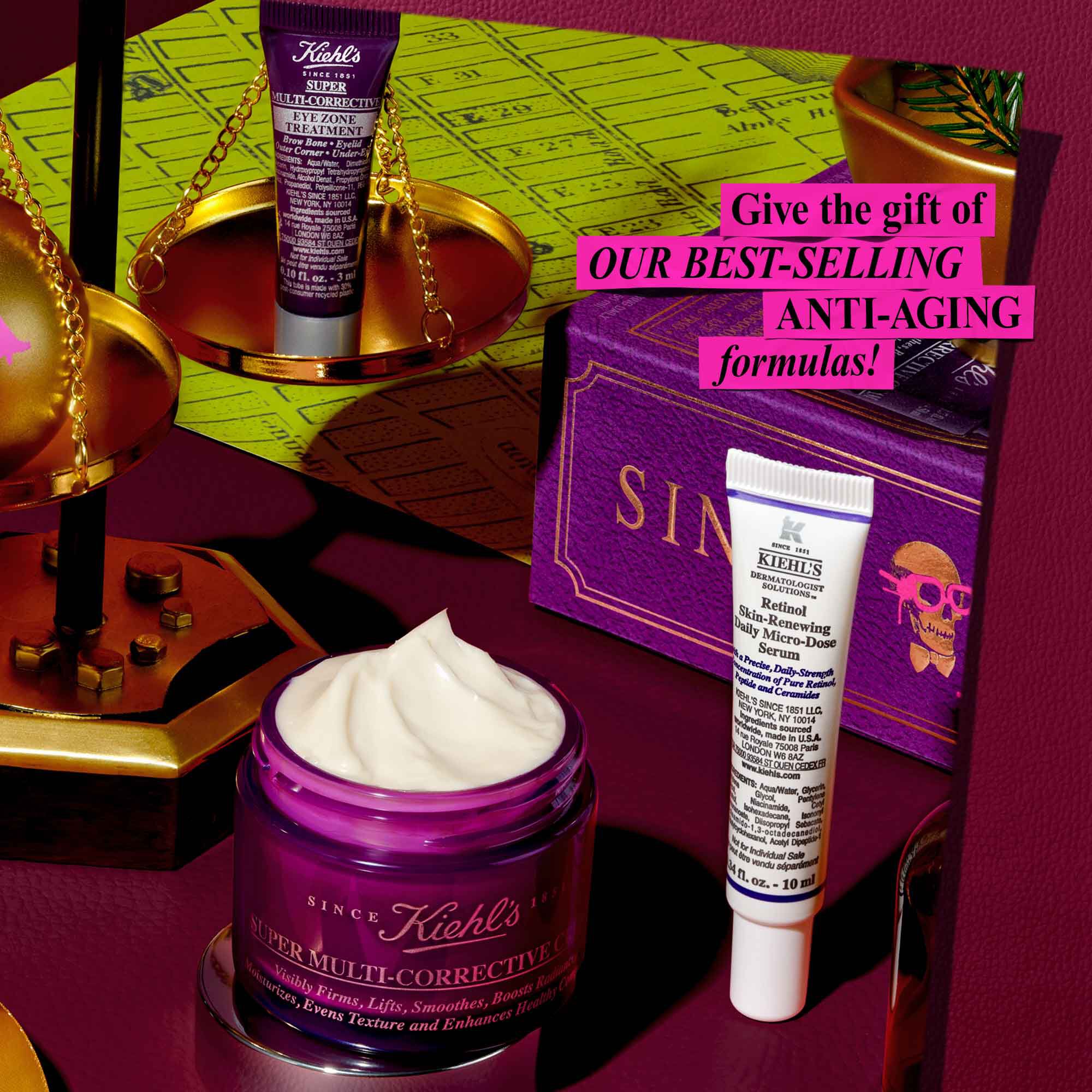 Slavnostni grafika na tmavě červenem pozadi se zelenym mapovym vzorem na zadni straně zobrazuje několik produktů a svatečnich dekoraci společnosti Kiehl's. Mala fialova tuba "Kiehl's Super Multi-Corrective Eye Zone Treatment" je vyvažena na zlate stupnici. V popředi je fialova nadoba "Kiehl's Super Multi-Corrective Cream" s viditelnou kremovou kremem. Bila a fialova tuba "Kiehl's Retinol Skin-Renewing Daily Micro-Dose Serum" stoji vedle fialove darkove krabičky s napisem "SINCE 1851" a designem lebky. Růžovy rameček s bilym textem hlasa: "Darujte NAŠE NEJPRODAVANĚJŠI ANTI-AGING receptury!"