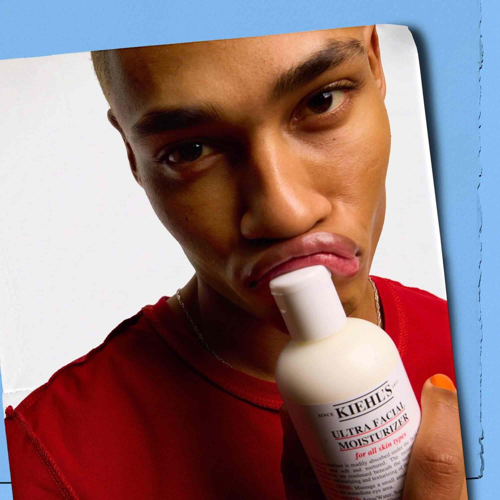 Modelka přikladajici lahvičku Kiehl's Ultra Facial Moisturizer ke rtům
