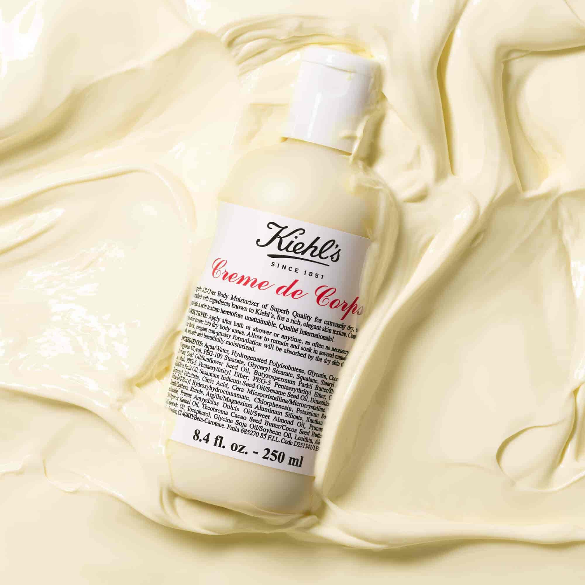 Lahvička Kiehl's Creme de Corps ve velkem množstvi texturovaneho těloveho mleka