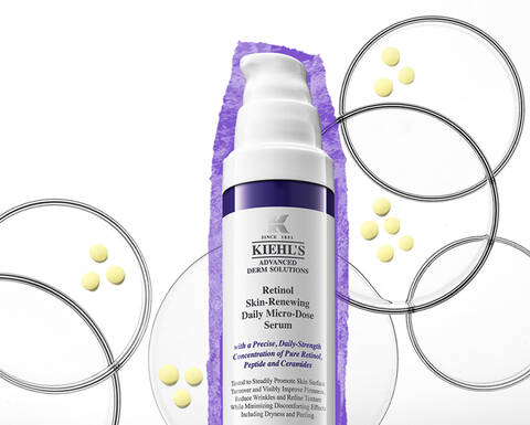Serum na pleť Kiehl's s retinolem na bile pozadi, obklopene barevnymi kuličkami a grafickymi kruhy.
