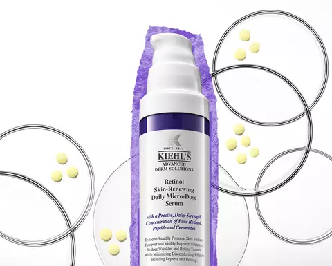 Serum na pleť Kiehl's s retinolem na bile pozadi, obklopene barevnymi kuličkami a grafickymi kruhy.