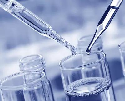 Two pipettes are shown above a glass container filled with liquid, with one pipette poised to release a drop. The image has a blue-tinted color scheme.