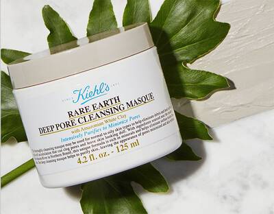 Bily kelimek na pleťovou masku Kiehl's s nazvem 'Rare Earth Deep Pore Cleansing Masque' na mramorovem povrchu.