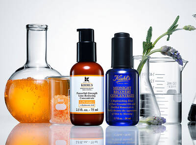 Skleněne nadoby s kosmetickymi produkty Kiehl's, zaměřene na pleť, obklopene pomerančovym serem a levanduli.
