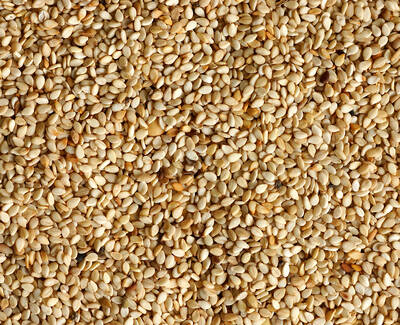 Close-up of a textured surface covered with small, light-colored sesame seeds.