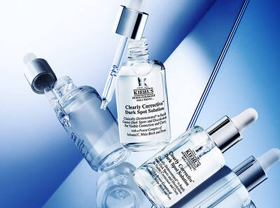 Serum Kiehl's Clearly Corrective Dark Spot Solution na bile a modre pozadi, zaměřene na redukci tmavych skvrn.