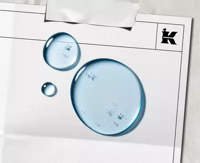 Modre kapky představujici α-Bisabolol na bilem listě s černym logem Kiehl's v rohu.