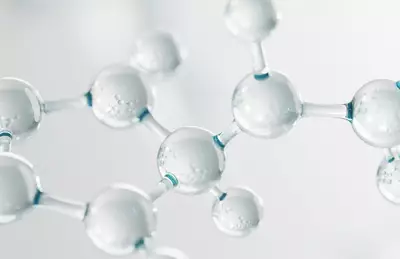 Close-up view of transparent molecular structures with spherical shapes and interconnected bonds, set against a soft, light background.