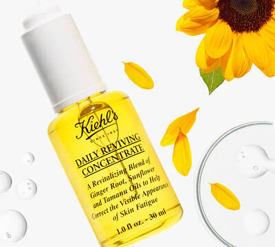 Mala lahvička s žlutou tekutou pleťovou konzistenci Kiehl's Daily Reviving Concentrate s slunečnicovymi okvětnimi platky.